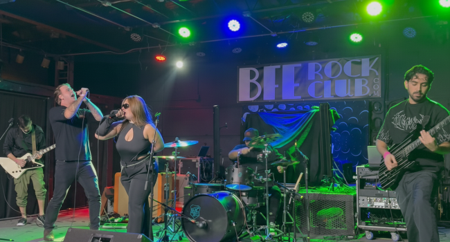 Second Illusion performing live at BFE Rock Club with lead singers and full band under colorful stage lights during an energetic rock performance.